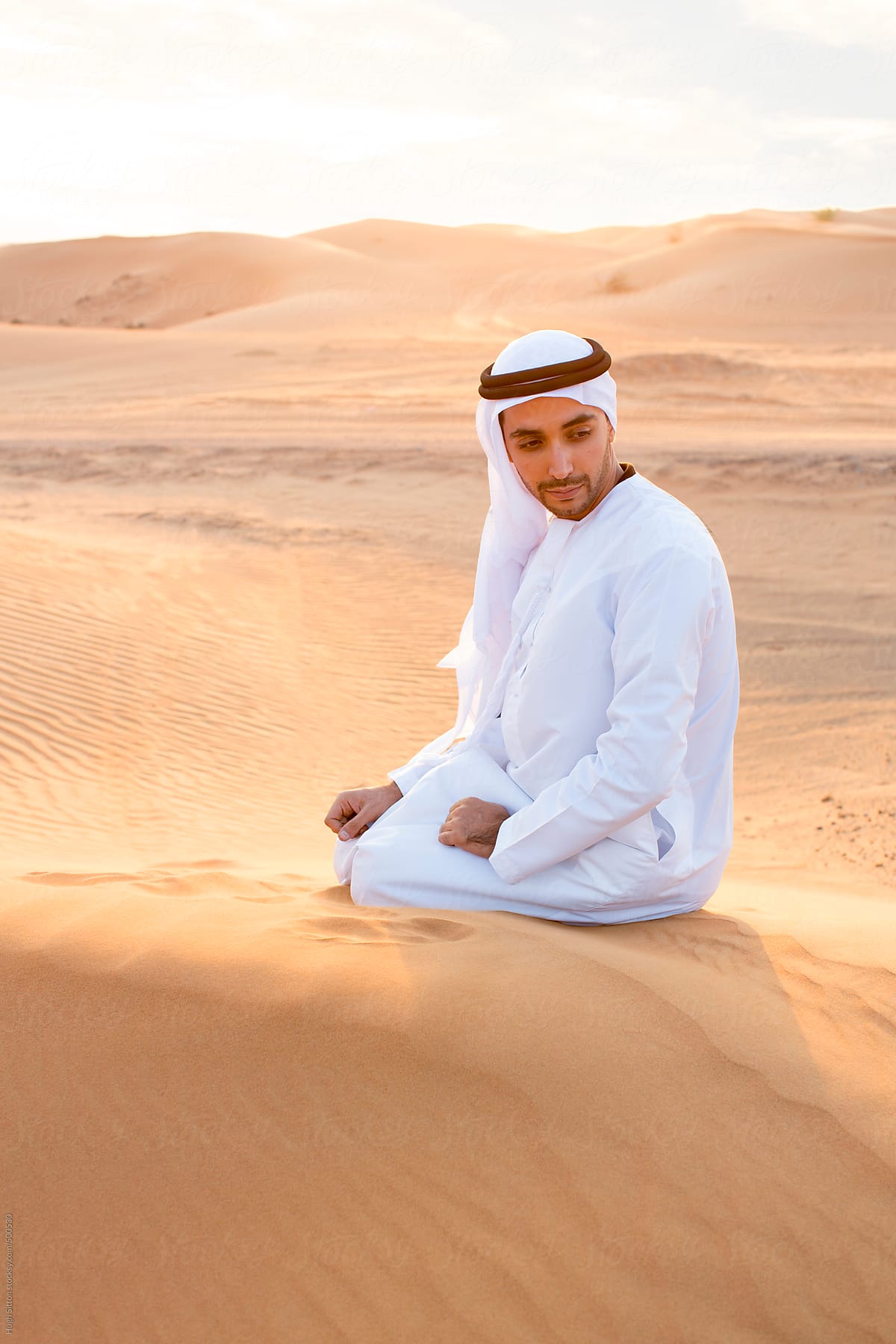 Arabian man wearing traditional costume in desert. Dubai. U.A.E