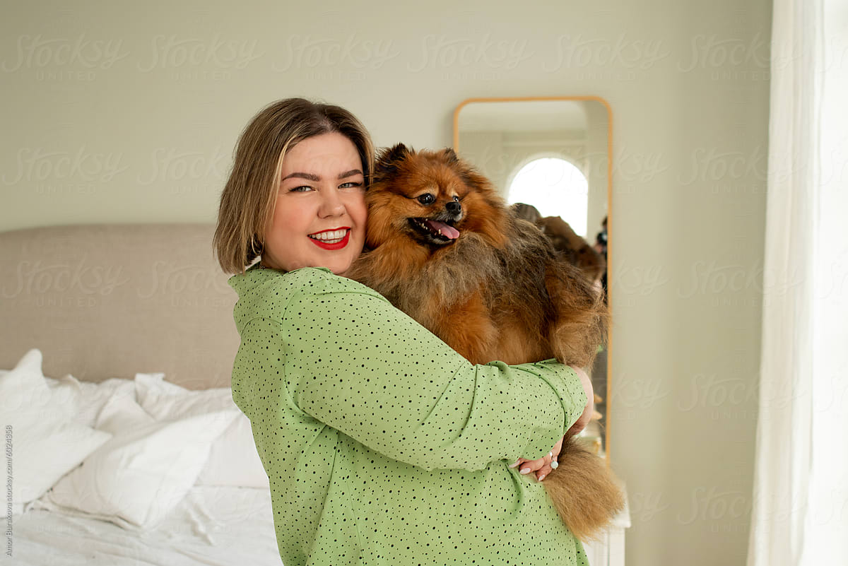 Smiling Woman Embracing Her Fluffy Brown Dog