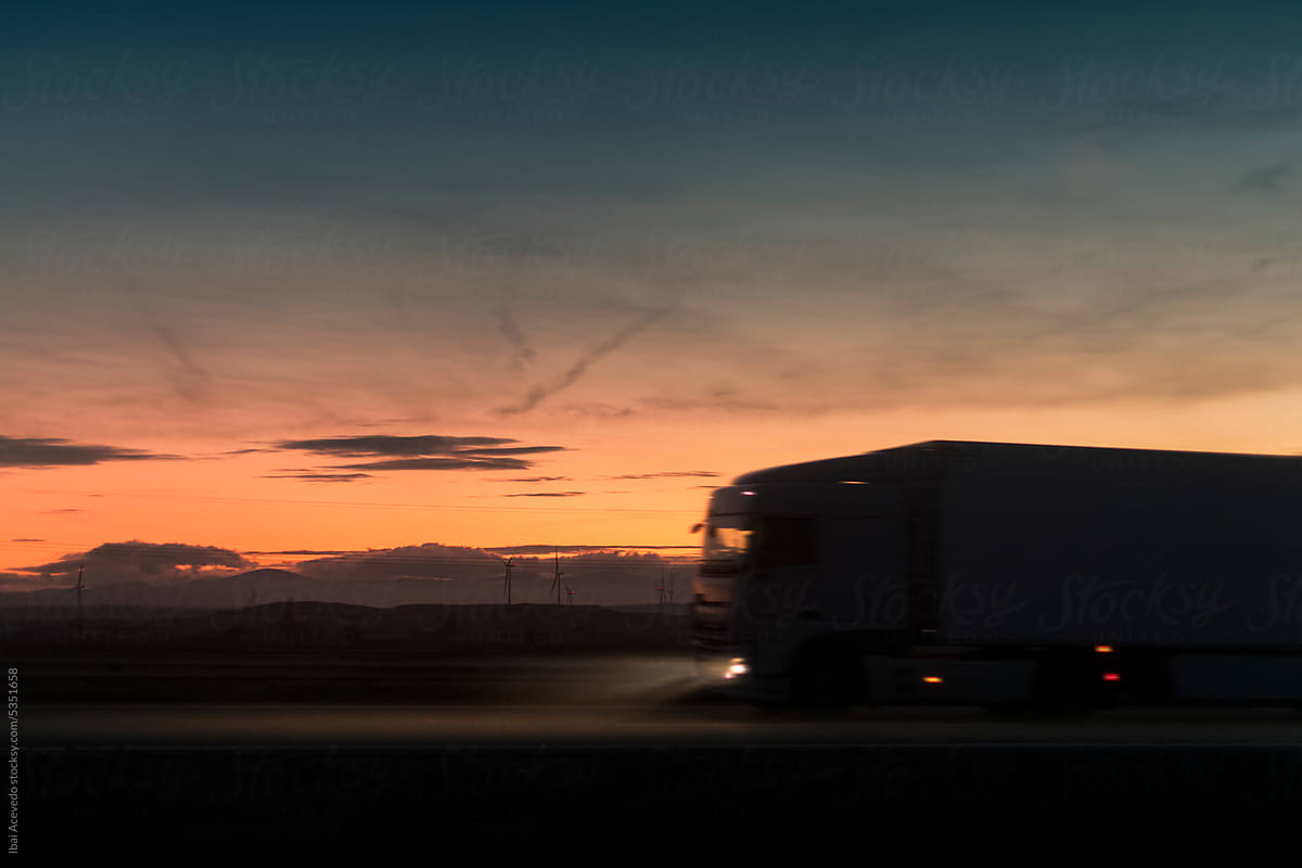 Truck and trailer silhouette at sunset during night drive
