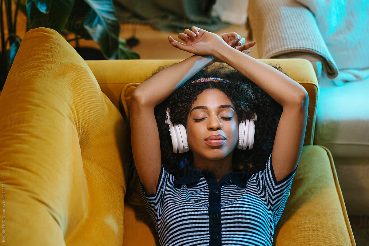 Black female in headphones on couch