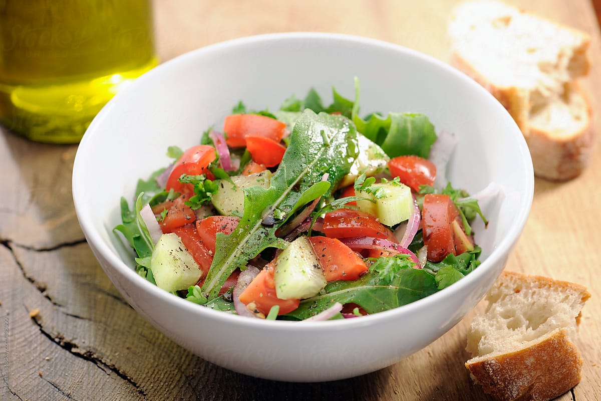 Food: Fresh salad with arugula, rocket, tomato and cucumber