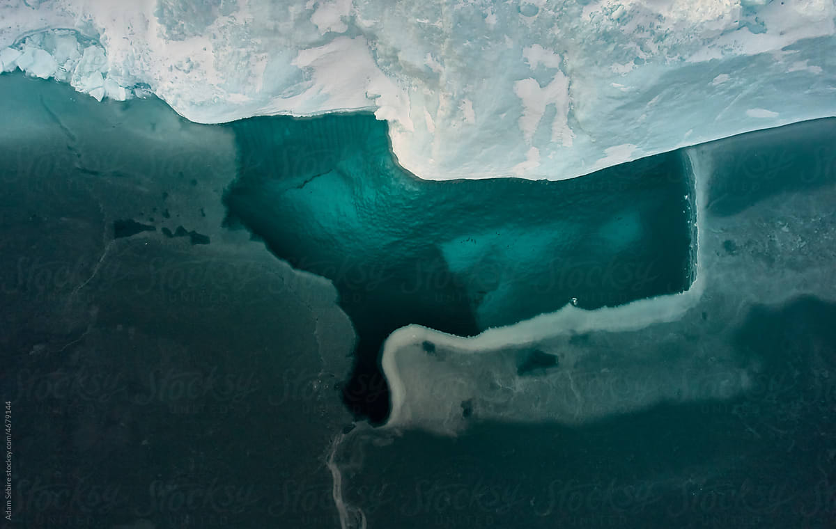 Bottom view of Greenland Arctic iceberg through sea ice underwater