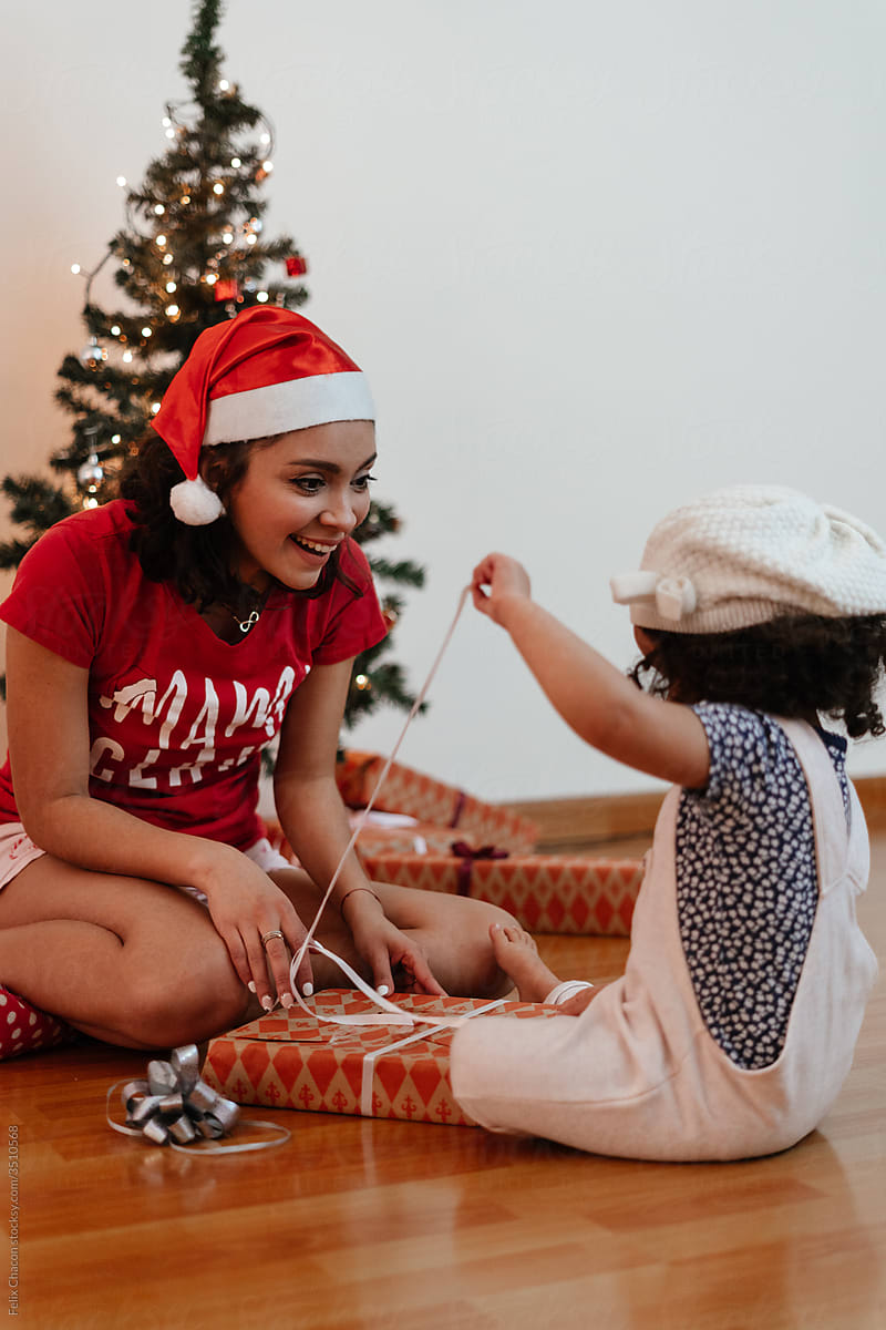 Little Girl Opening A Present Gift With Her Mom