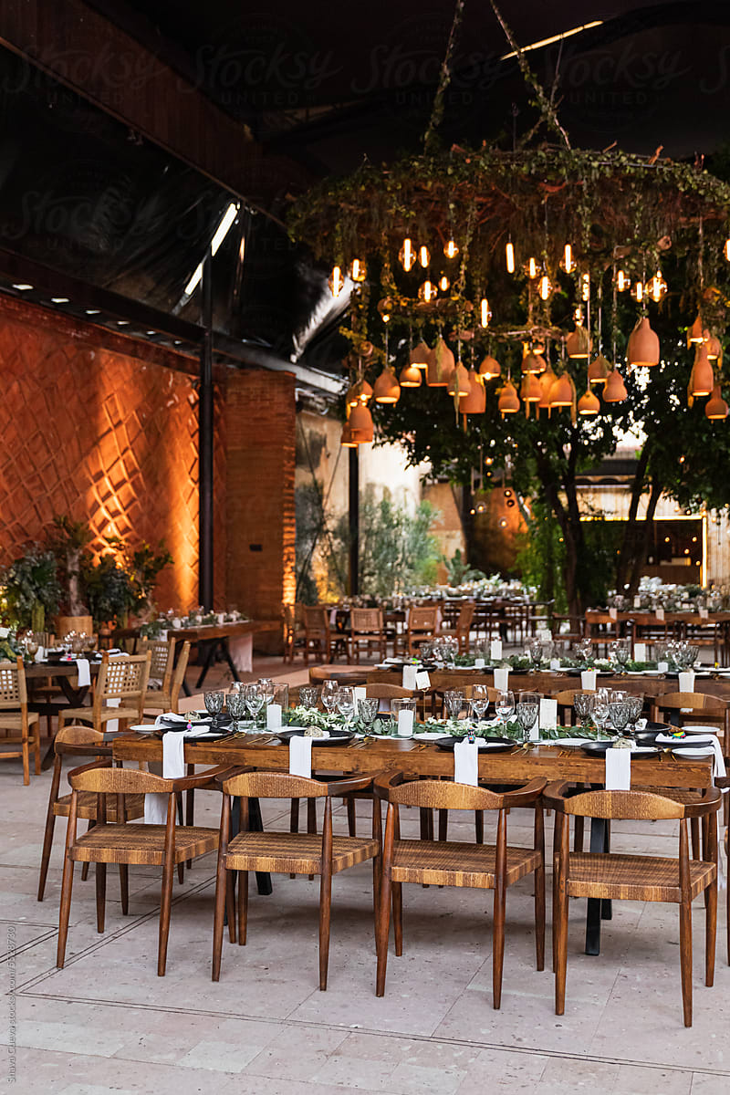 A wedding set up with wooden tables and chairs