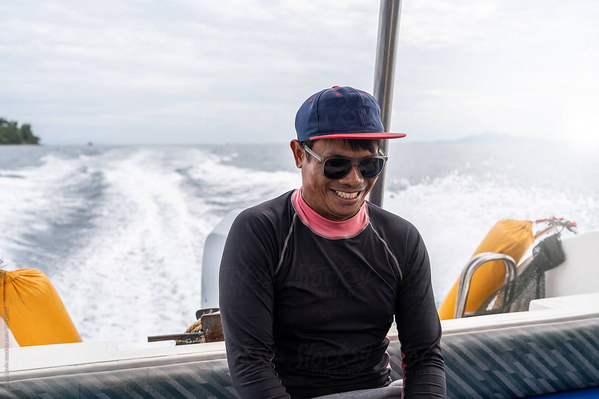 Man smiling while traveling on a boat.