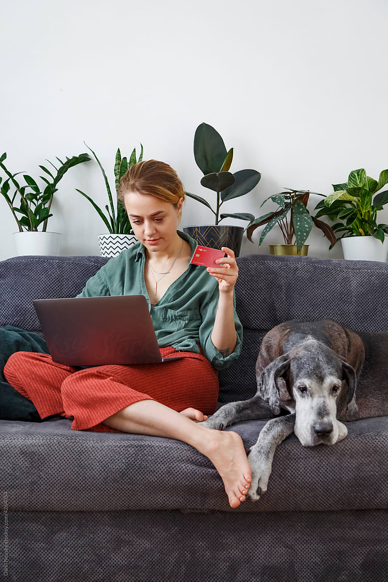 Woman making online purchase near dog