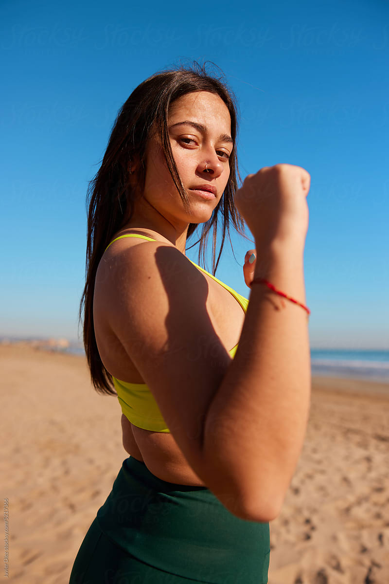 Sportswoman standing with fist defense gesture on beach