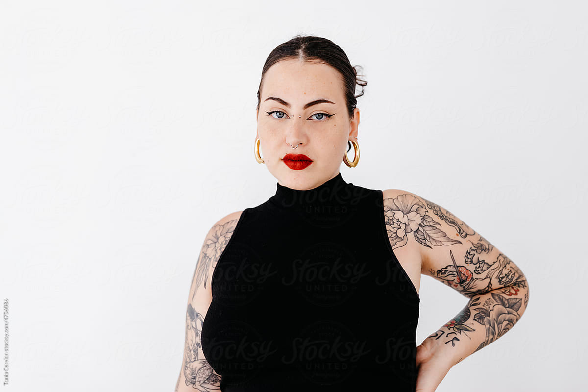 Stylish tattooed woman in studio