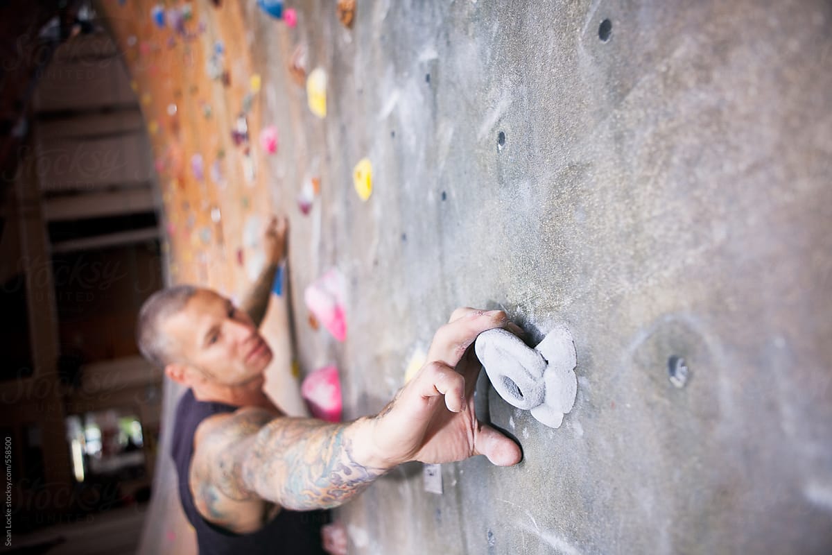 Climbin: Man Grips Rock As He Climbs Wall