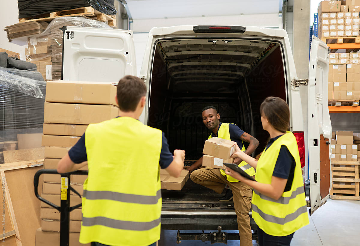 Teamwork In Logistics. Unloading Delivery Van.