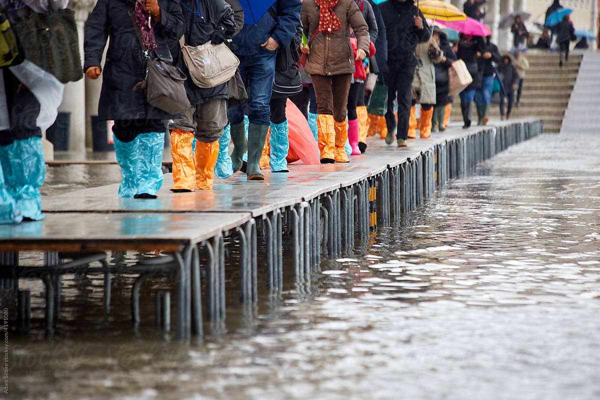 Water floods Venice footpaths, feet on raised walkway