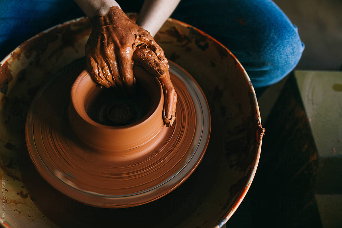 Crop artisan making clay pot on wheel