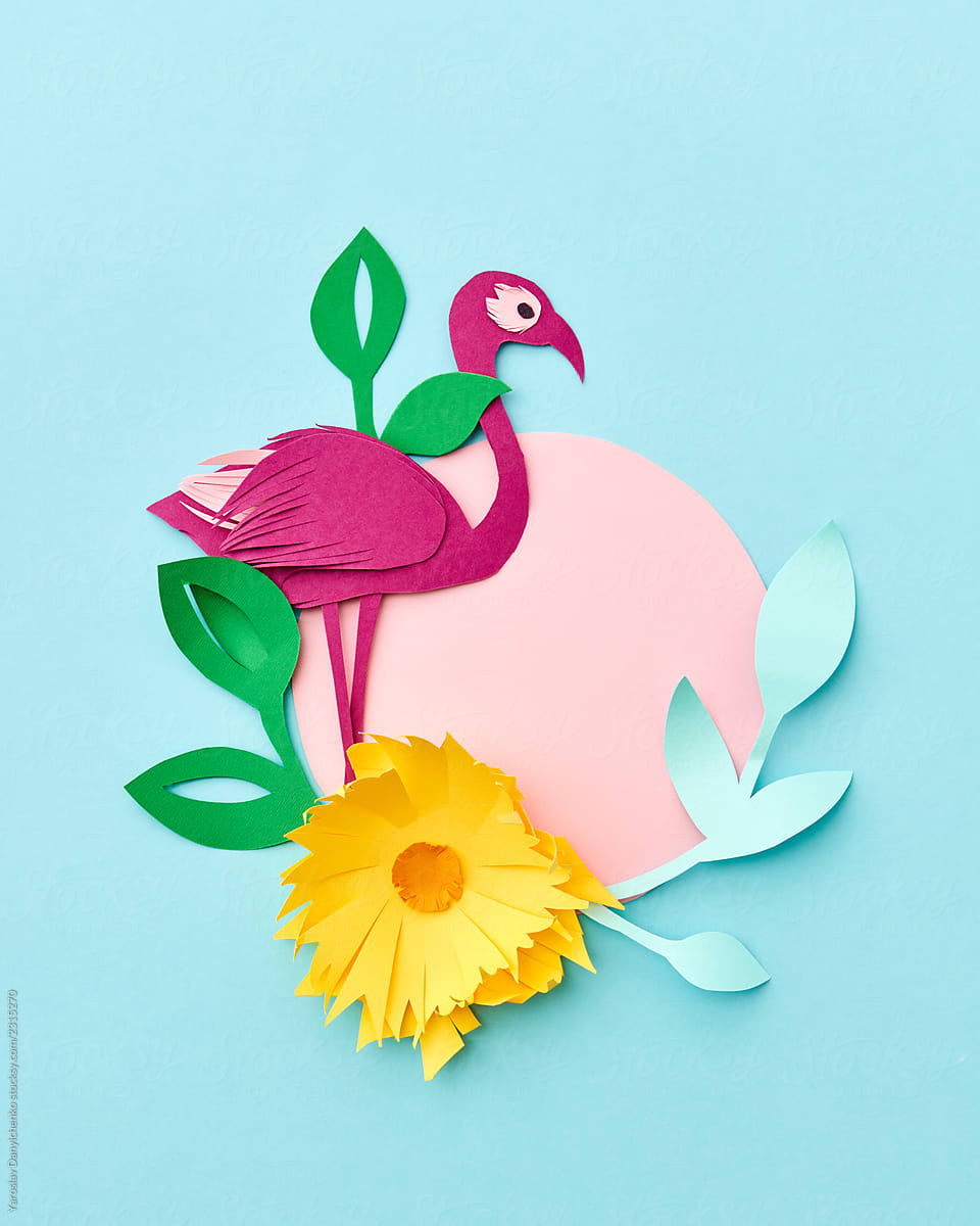 Summer greeting card with handcraft application from colored paper, tropical flowers and pink flamingo on a light blue paper.
