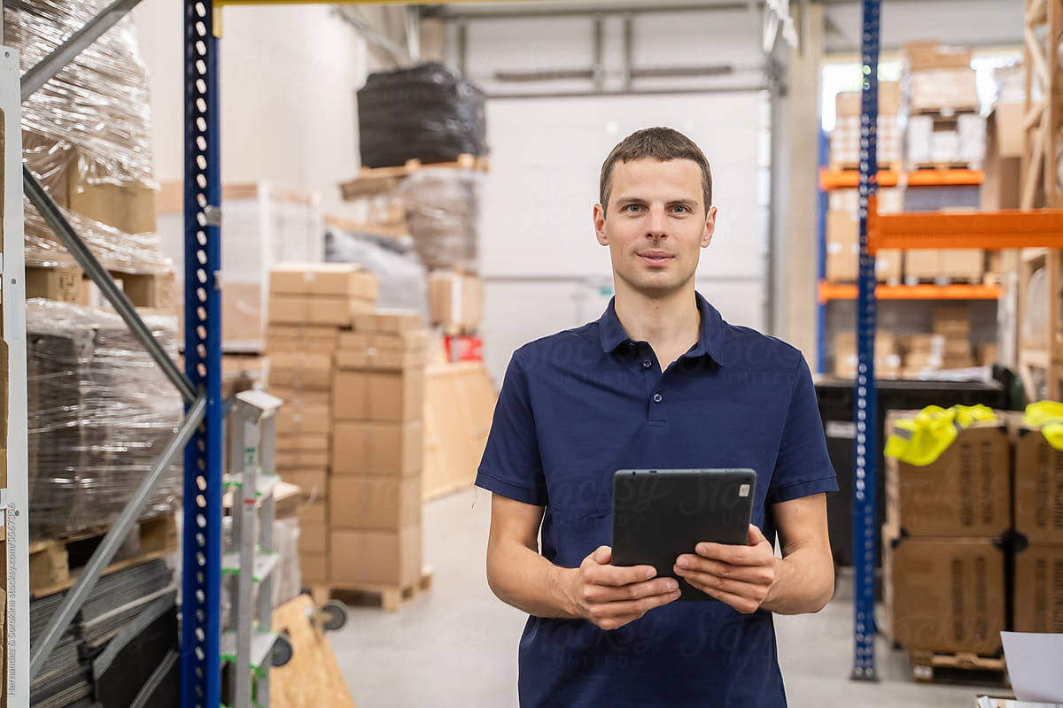 Smiling Man Holding Tablet At Warehouse