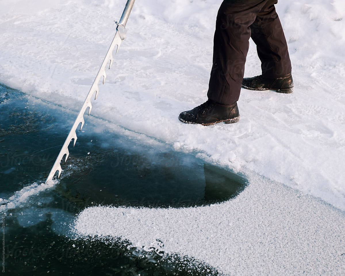 Men cut ice with a saw on the river, winter, ice-hole.