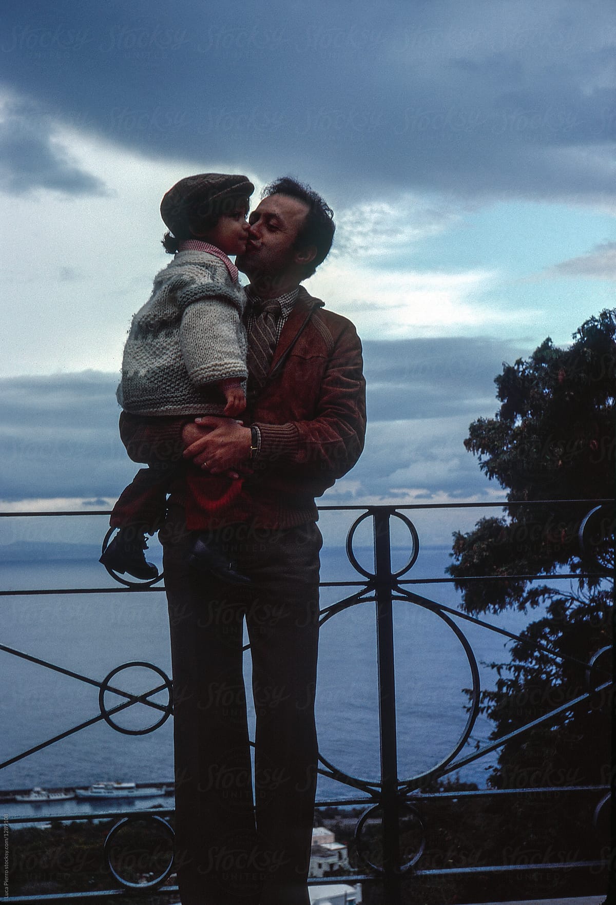 1981. Father kissing his son on the cheek