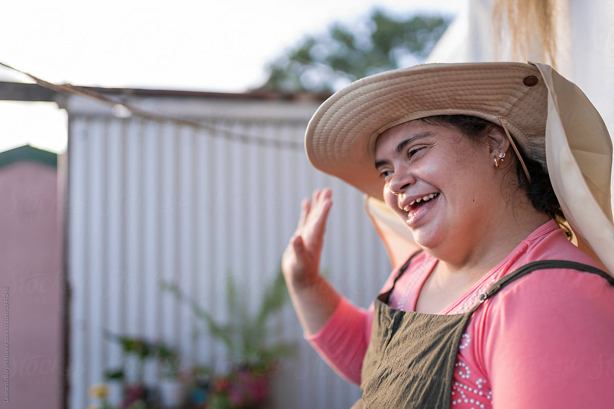 Woman with down syndrome smiling while greeting.
