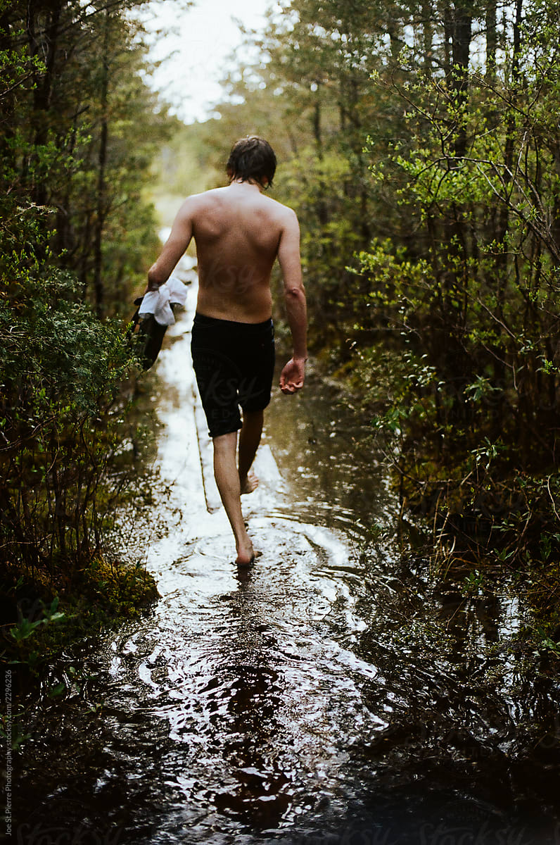 Man Walking Through Flooded Nature Trail