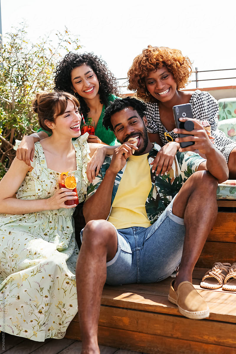 Optimistic diverse friends taking selfie together in summer