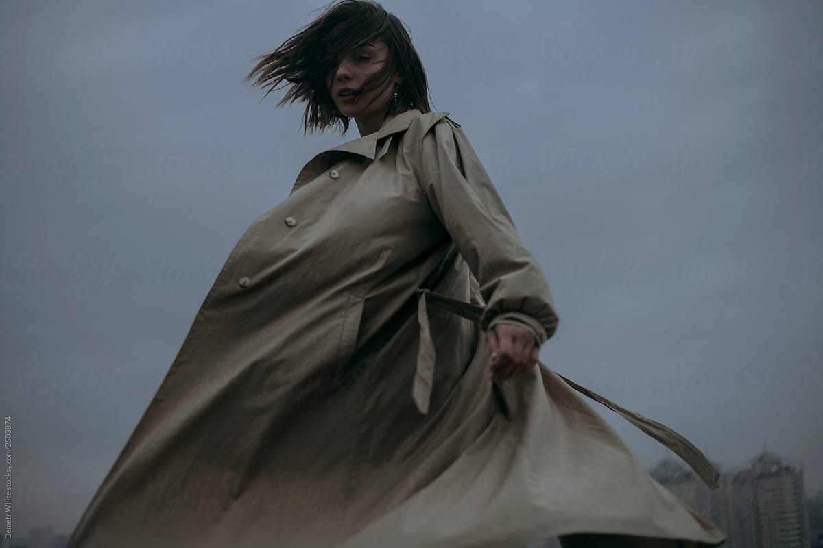 girl in a flying coat\
 and hair against the evening sky