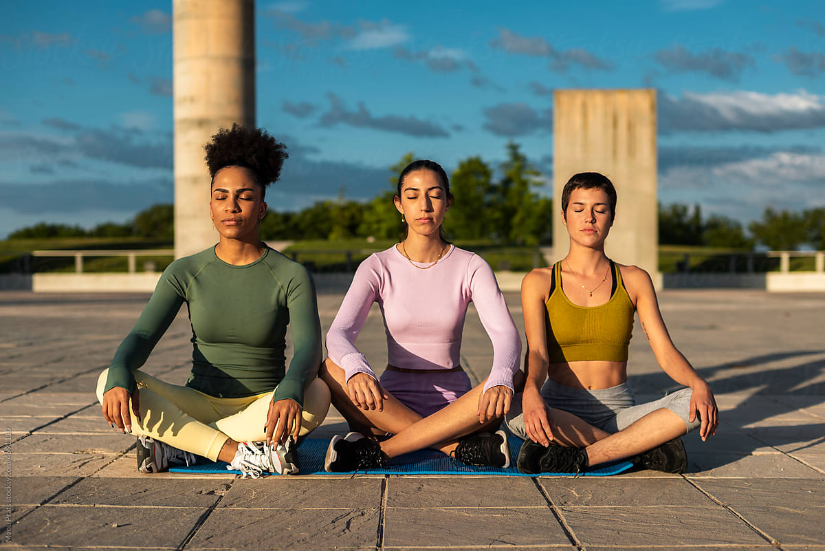 Diverse women meditating outdoors