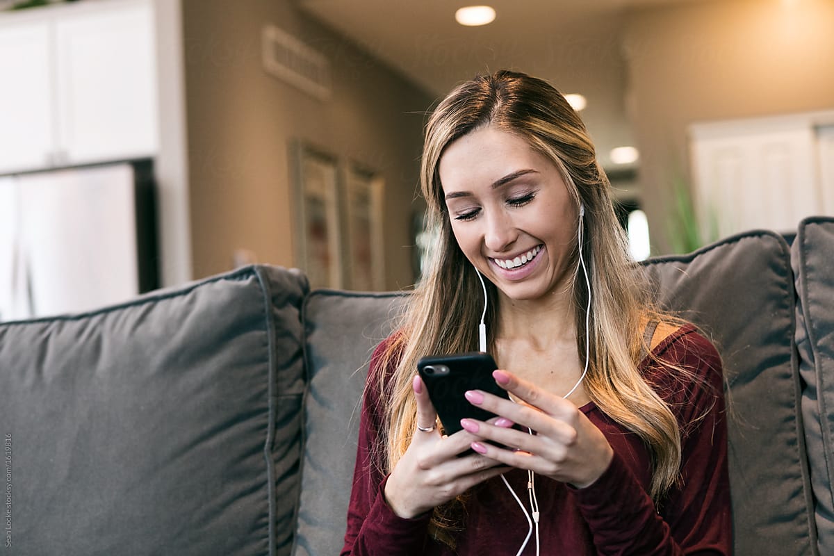 Home: Girl Smiles While Listening To Music On Cell Phone