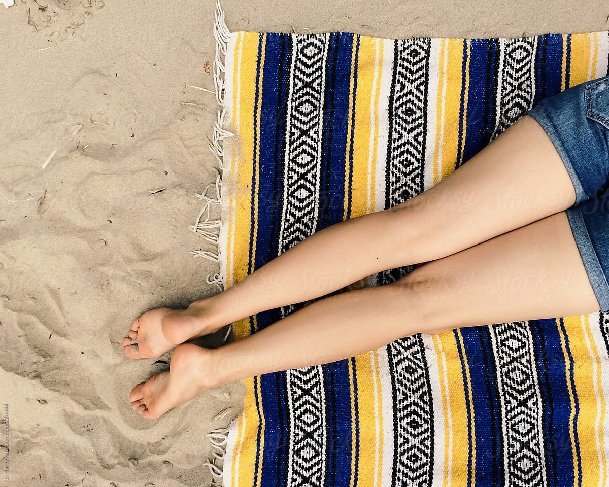 Cute Girl\'s Legs on a Blanket at the Beach