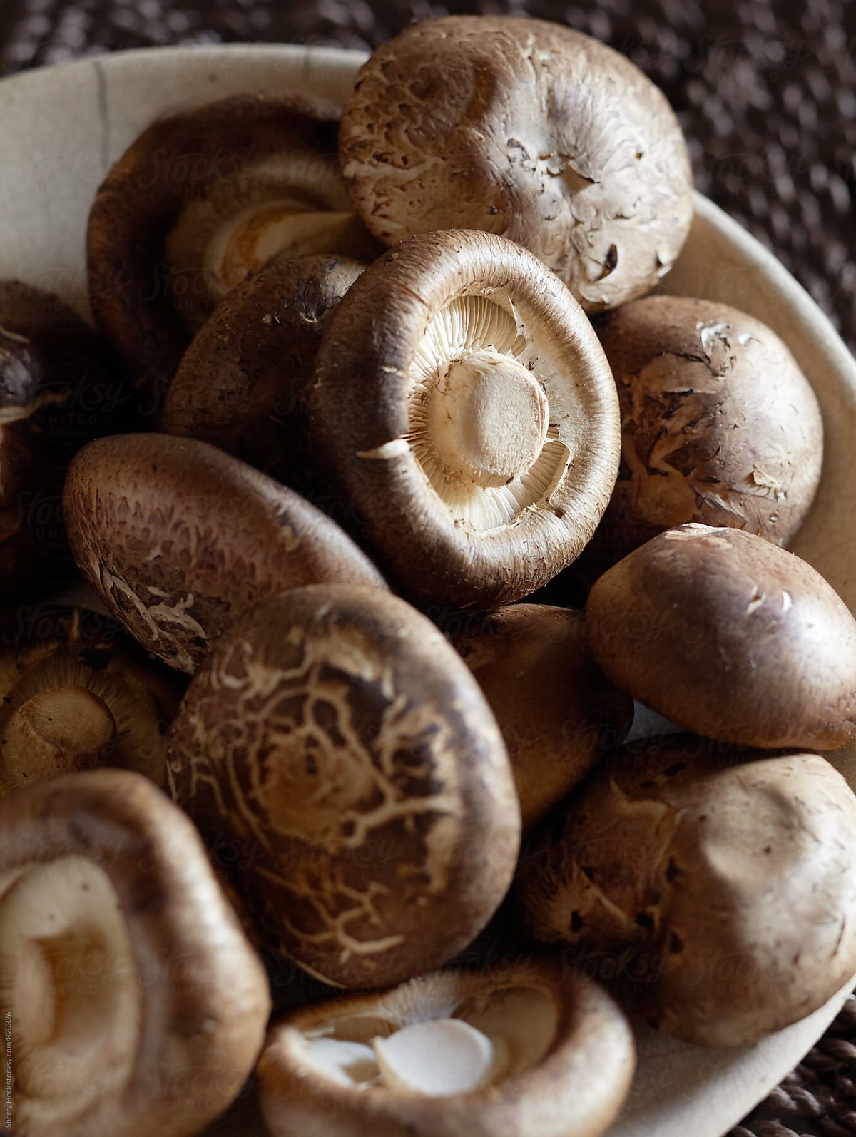 White bowl of brown mushrooms showing texture