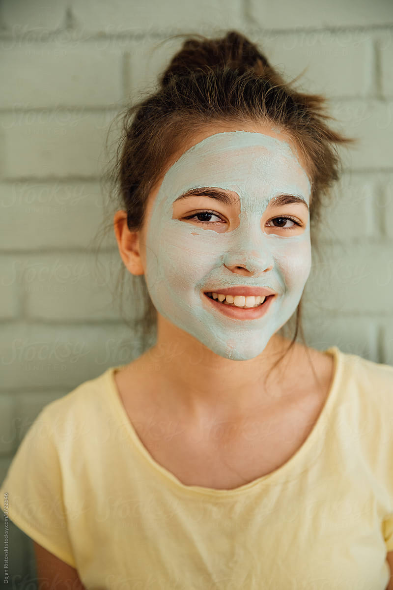 Portrait of a teen girl with clay mask on  her face