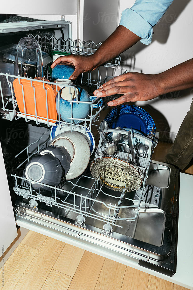 Man Taking out Dishes from a Dishwasher