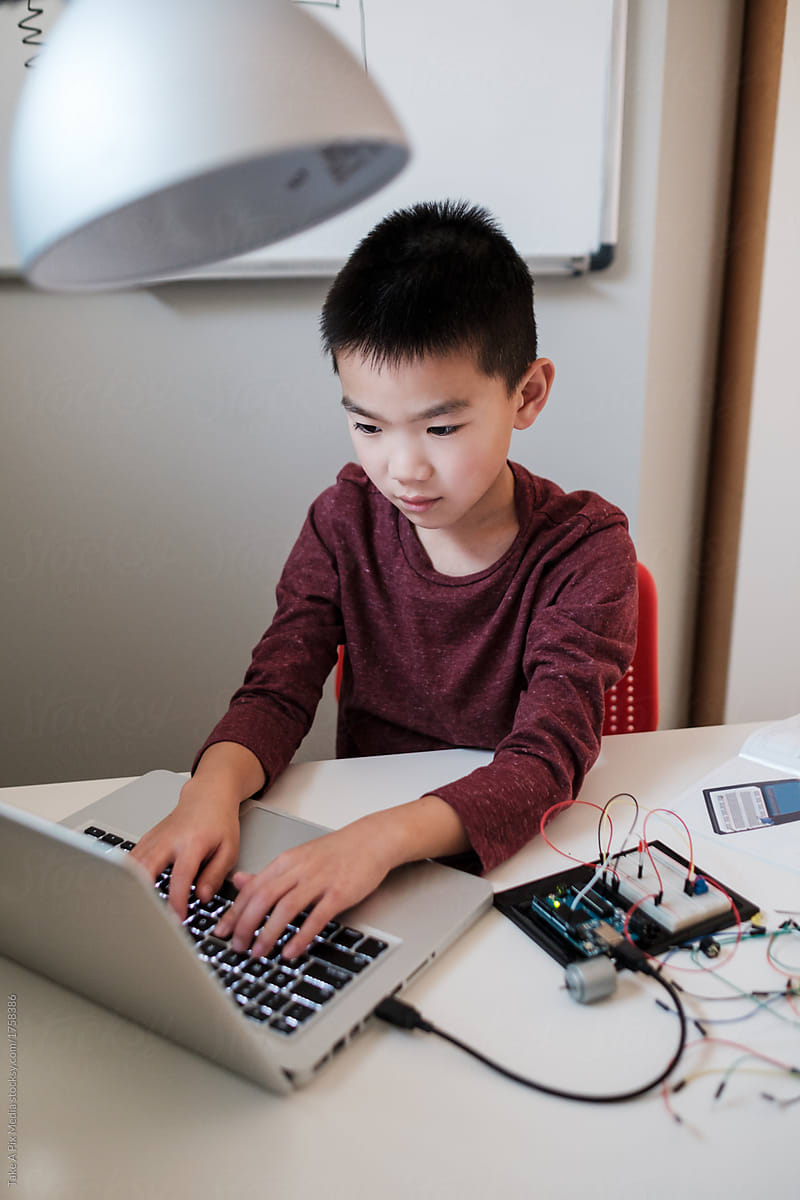 Asian Boy Working on an Electronic DIY Kit at Home