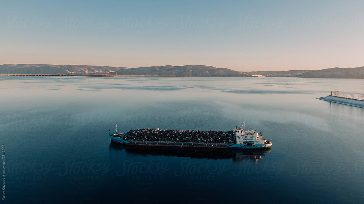 Aerial view of a cargo ship against the mountain chain