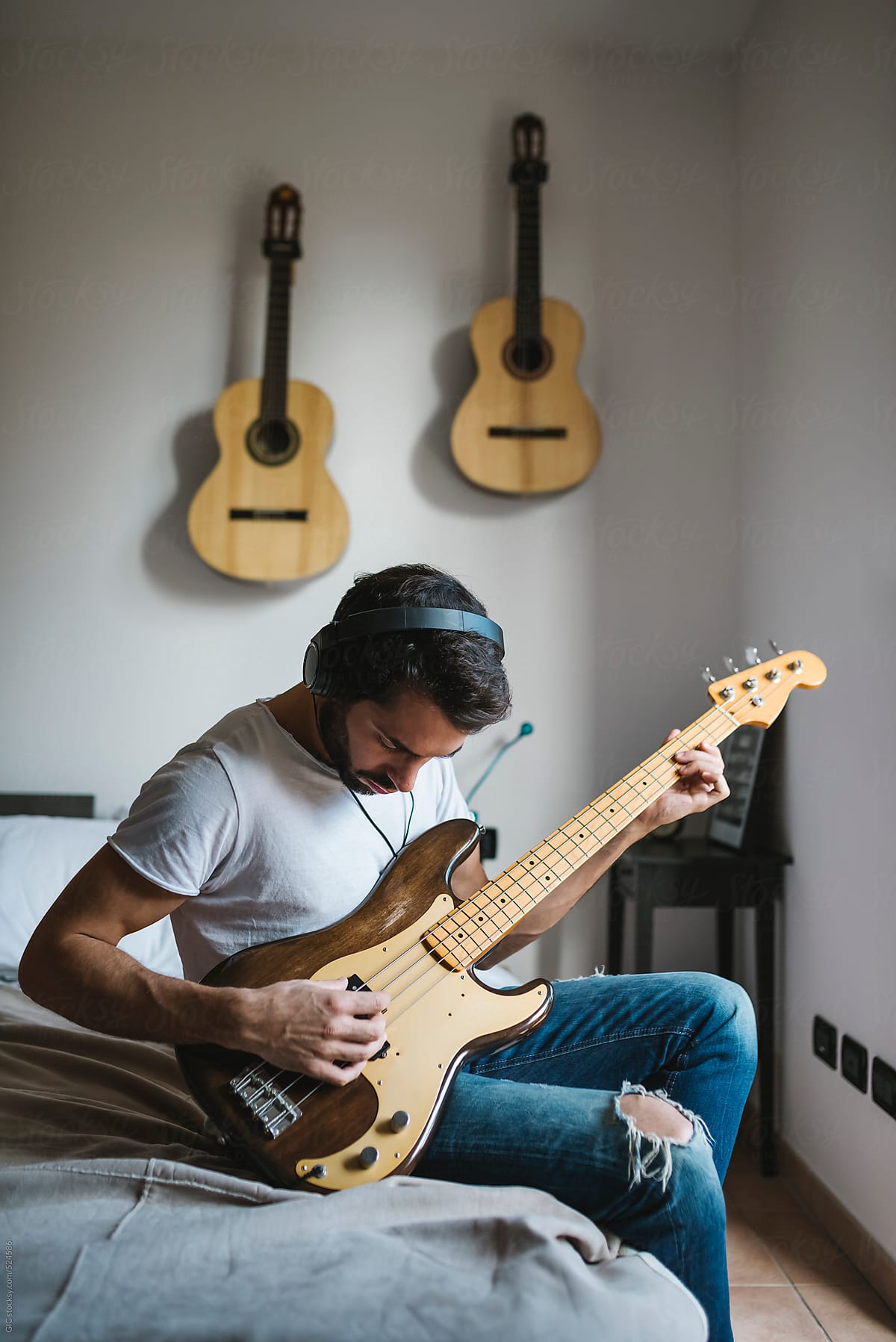 Man Playing Bass Guitar At Home by Stocksy Contributor Simone