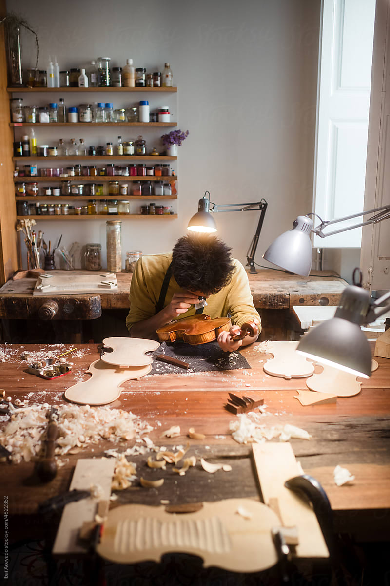 Passionate violin luthier working at studio