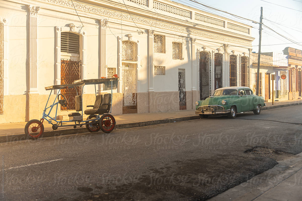 Green Car And Rickshaw Parked Near Antique Building
