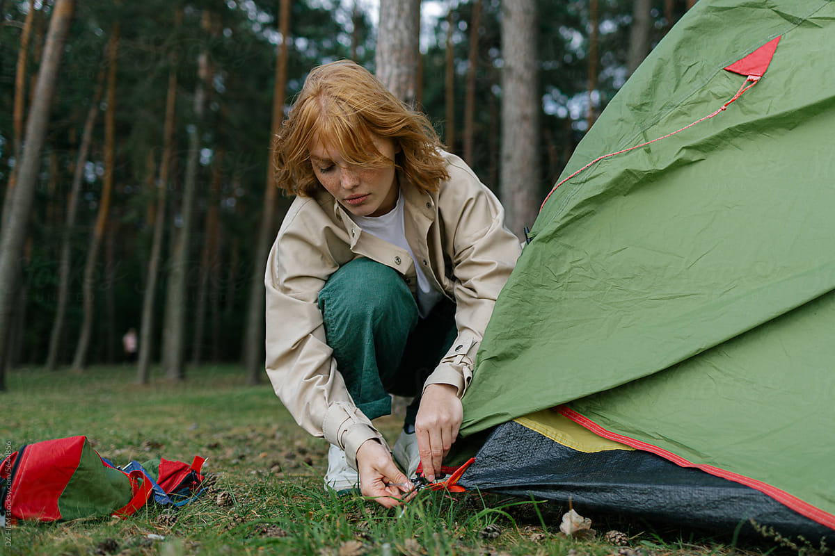 A woman sets up a tent