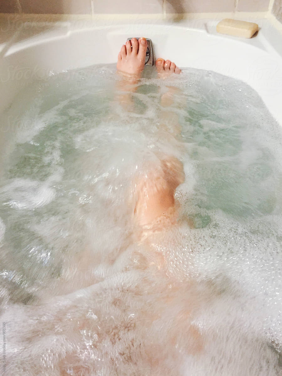 Woman relaxing in whirlpool bathtub with jets turned on