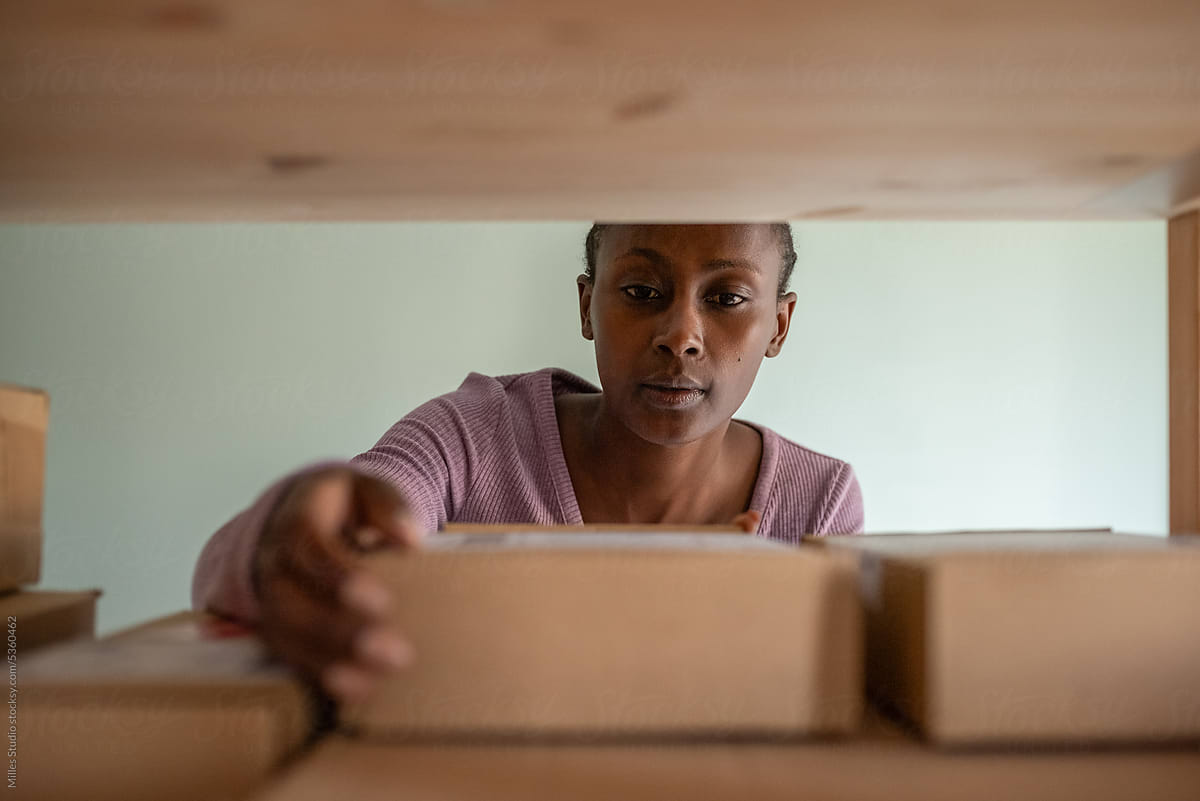 Black woman checking parcels on shelves
