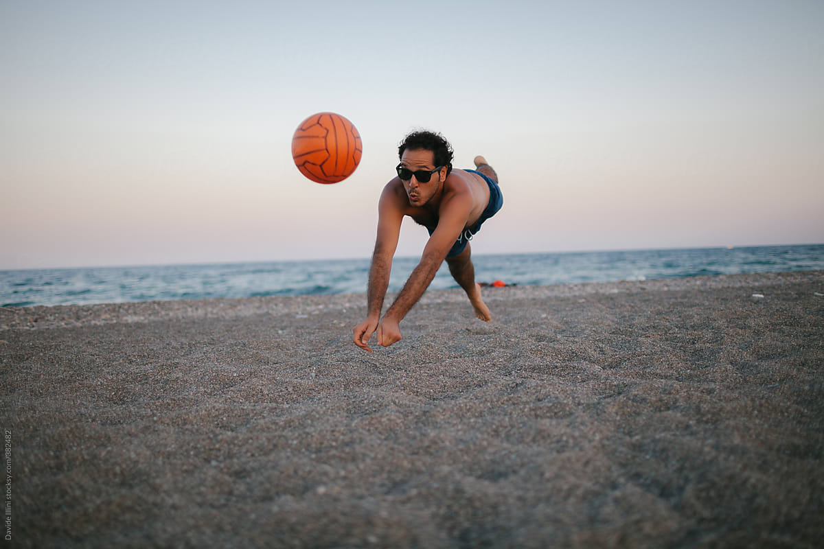 Young man playing volleyball on the beach