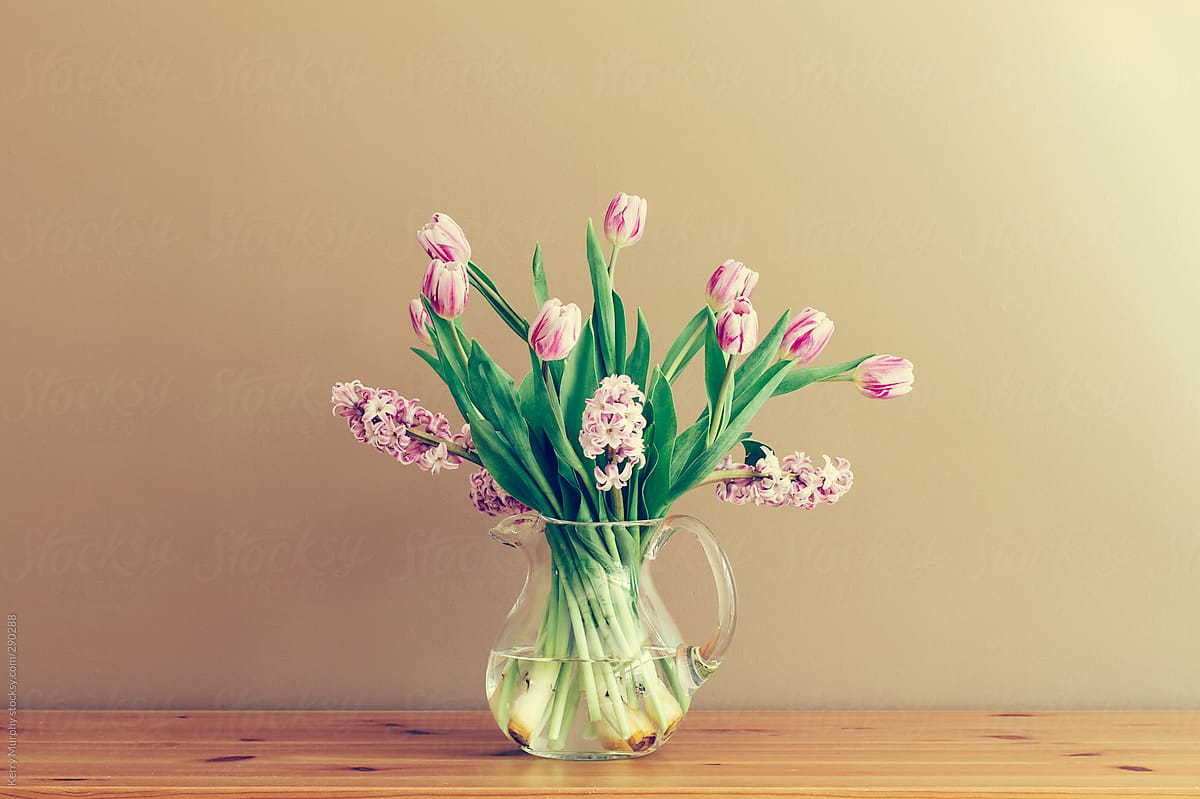 Vase of tulips and hyacinth on wooden table