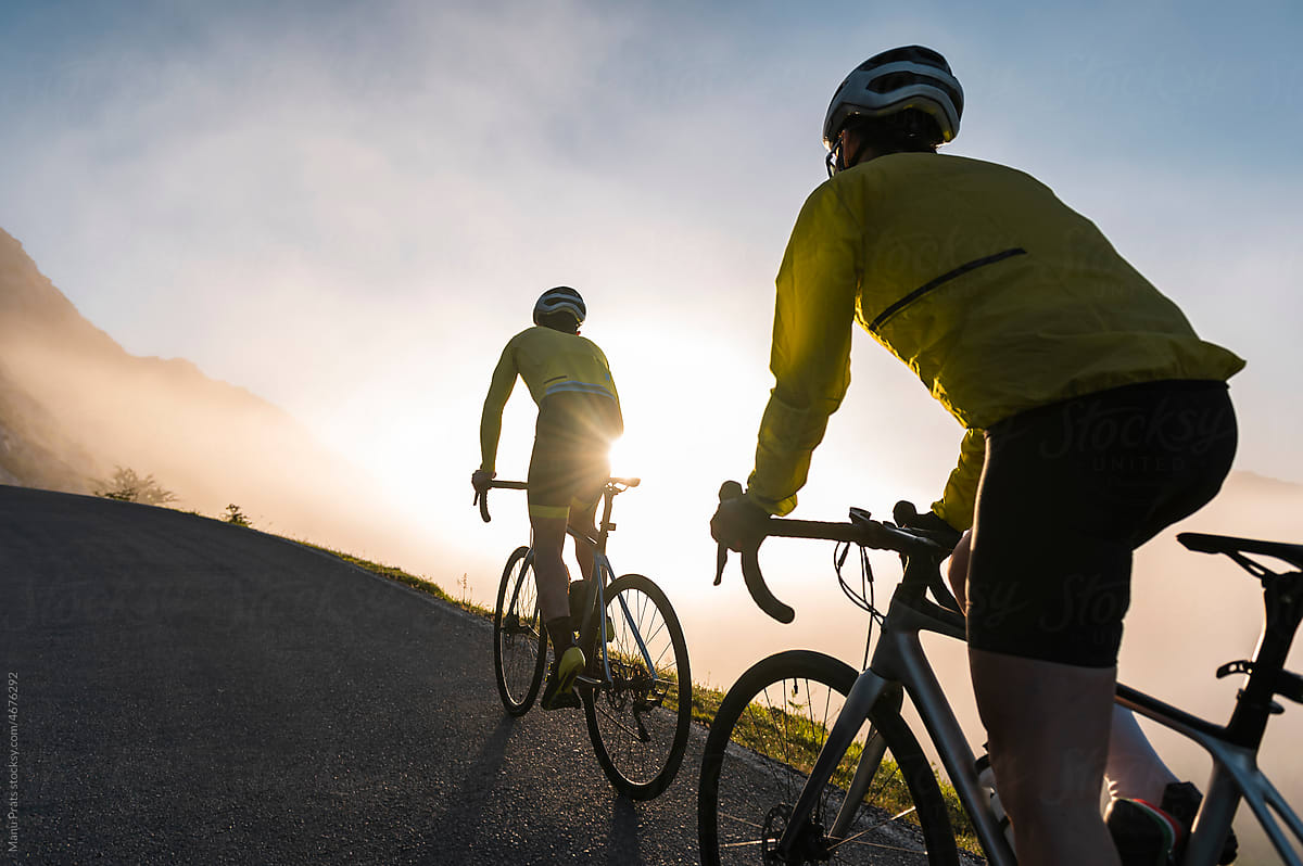 Man and woman cycling together on misty morning