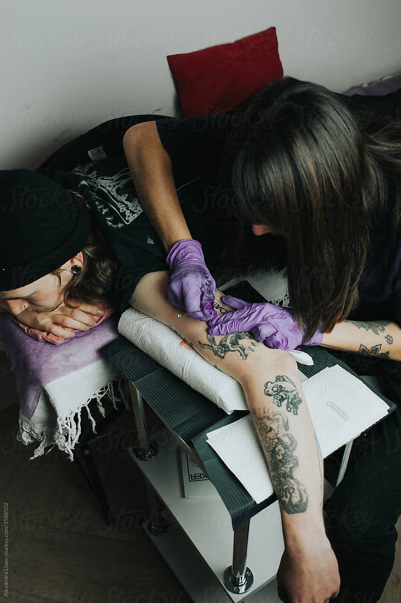 Tattoo master make a hand poke tattoo