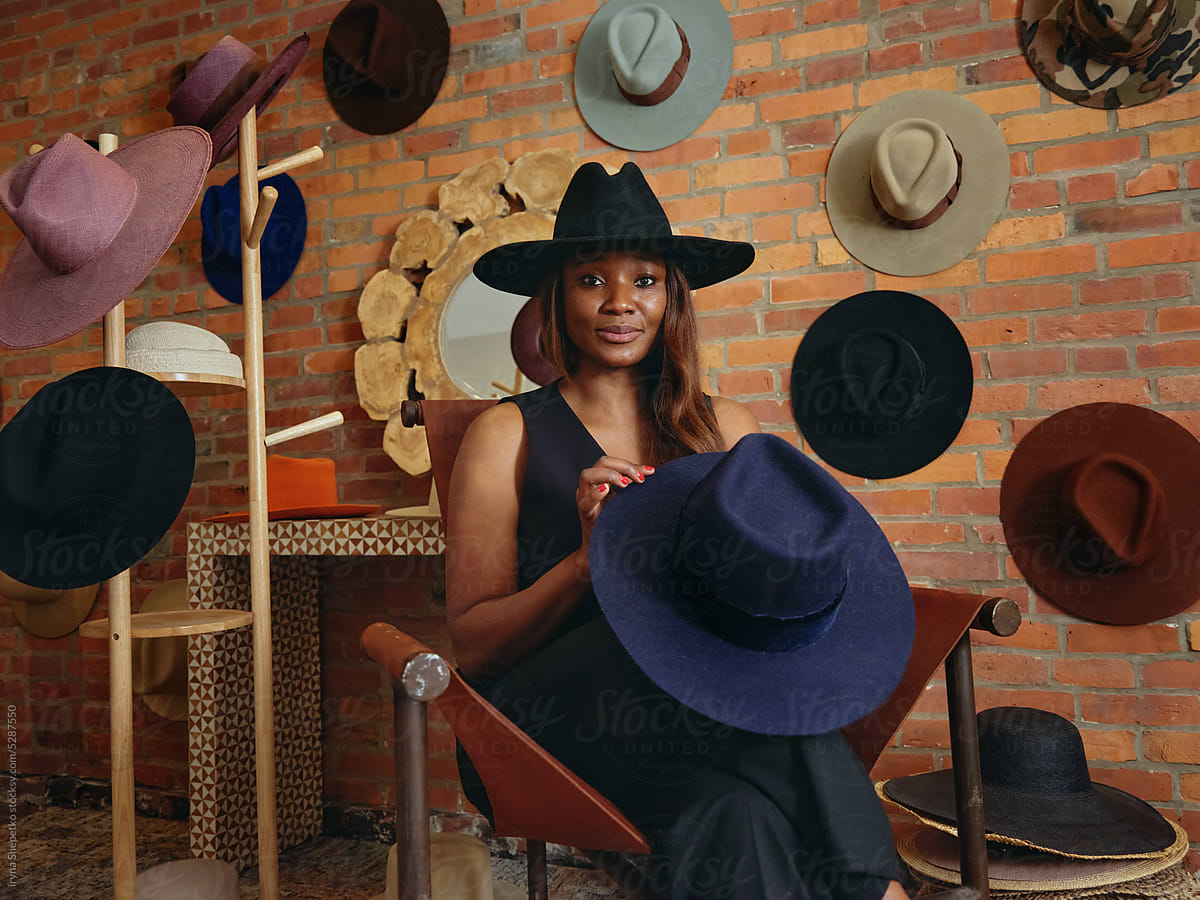 Elegant black woman in a hat in a showroom studio