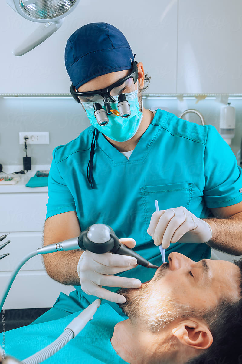Dental Surgeon checking patient teeth with instruments