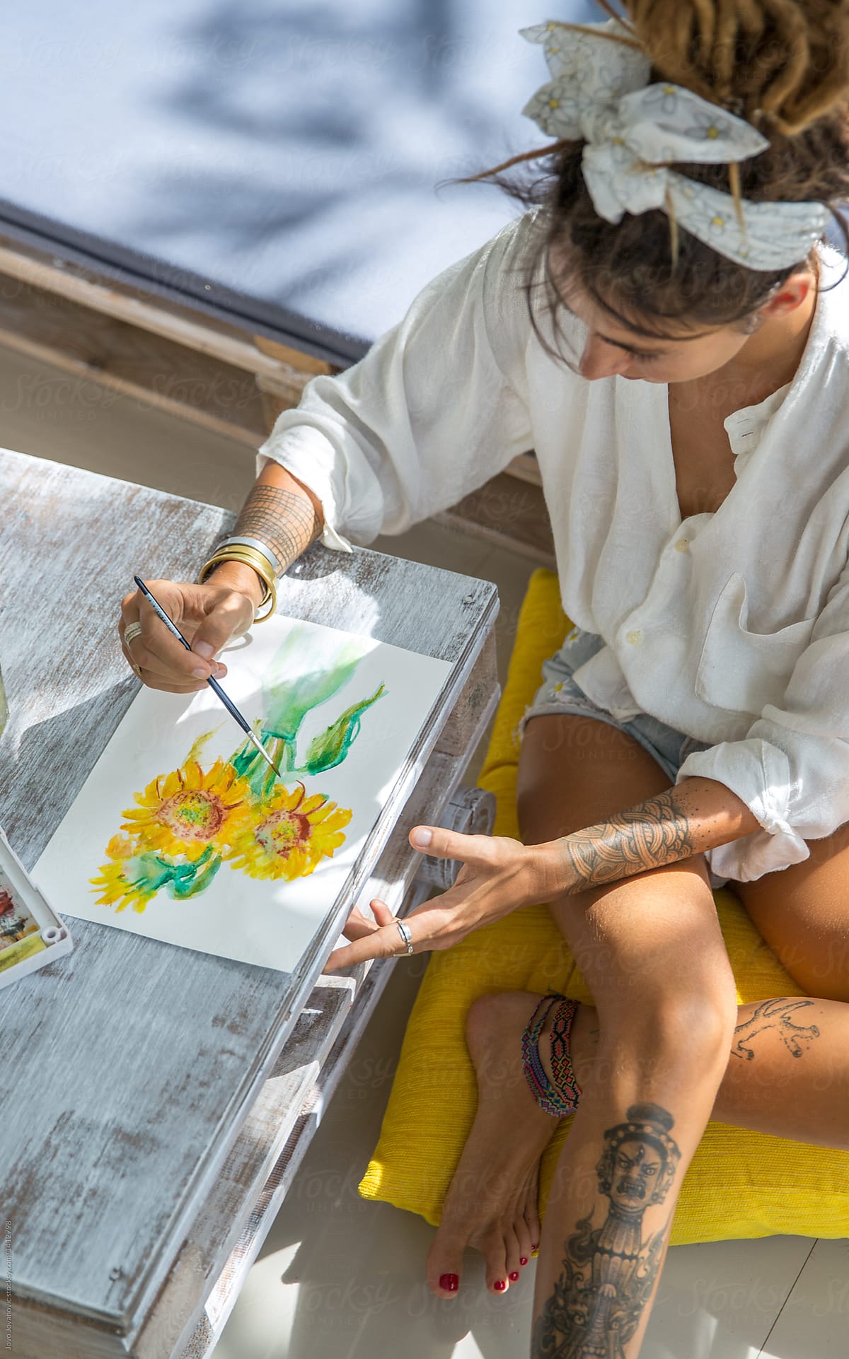 Woman artist drawing sunflowers on paper