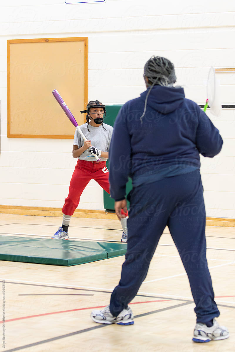 Senior woman training a child on proper softball bat handling