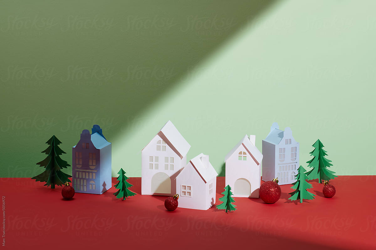 Decorative white house with a spruce tree on red table
