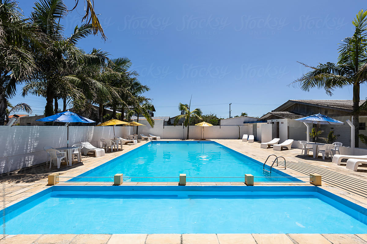 Swimming pool and lounge area with hammocks, tables and beach umbrella