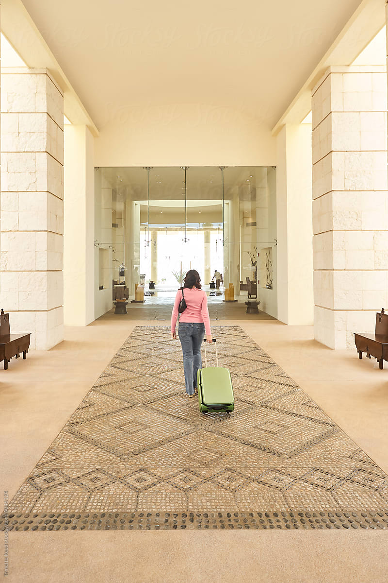 Woman at luxury hotel traveling with suitcase