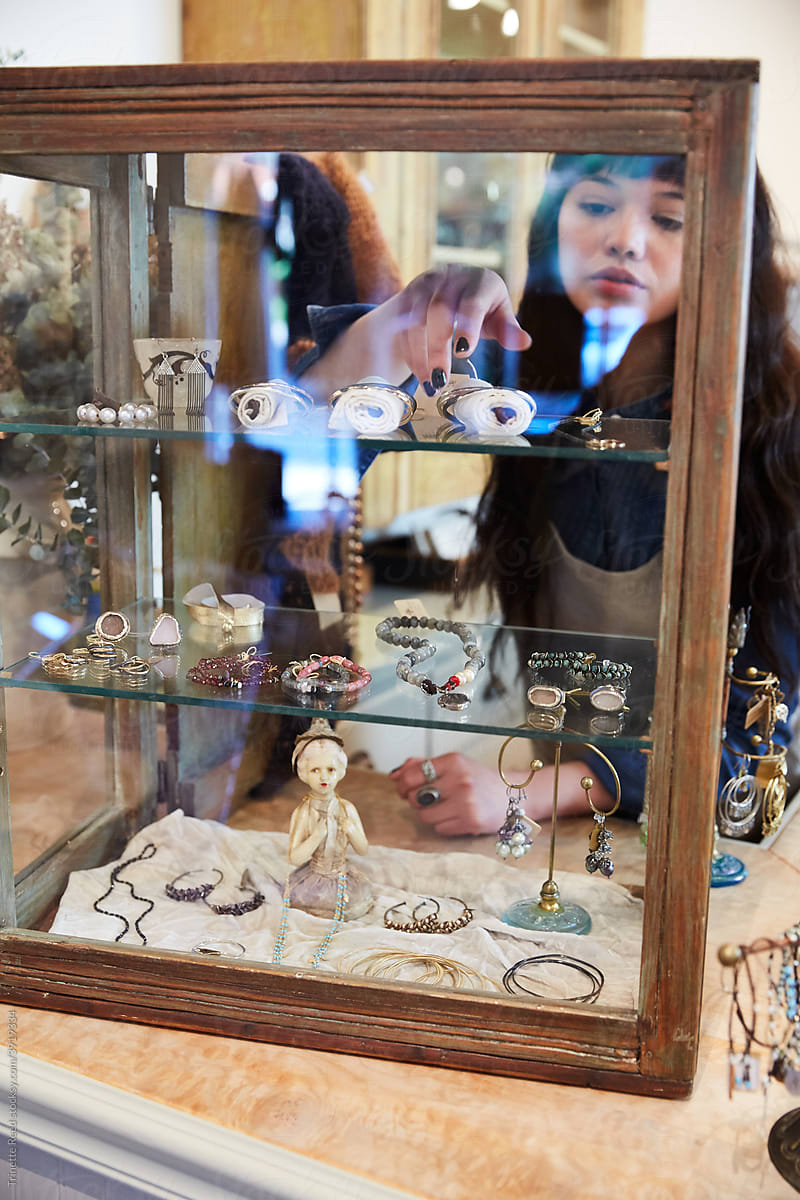 Store owner arranging jewelry in case